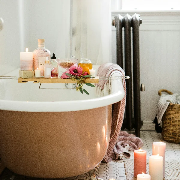 There are flowers scented candles etc placed on the tray table above the bathtub